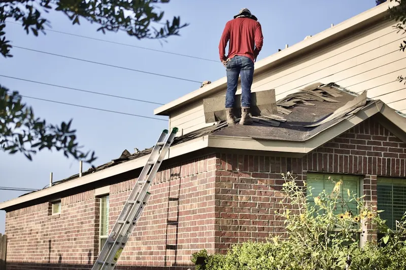 Professional roofer working on a residential roof in The Oaks at Five Farms